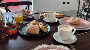 A breakfast table with pastries, fruit, and beverages. - Rosa y Oro Hotel Boutique (Jesús María)