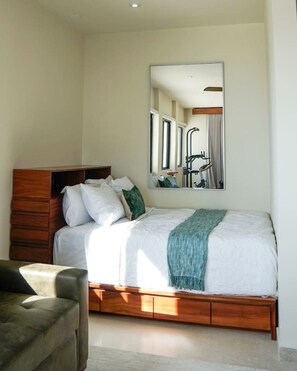 Una camera da letto con un letto, una testiera in legno, uno specchio e una finestra.