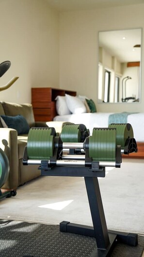 Un espace de remise en forme aménagé à la maison, comprenant un vélo d’appartement et un banc de musculation.