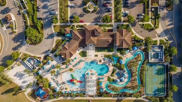 An aerial view of a resort with a large pool, a water slide, and a basketball court. - Family Oasis! Luxe 5BD/4.5BA Townhouse w/Private pool, Disney Proximity (Kissimmee)
