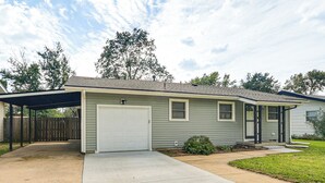 A single-story house with a covered garage, a front yard, and a wooden fence. - 2 Mi to Zoo, Fenced Yard: Family Home in Wichita! (Wichita)