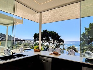 Une cuisine moderne dotée d’une grande fenêtre, d’un évier et d’un égouttoir à vaisselle.