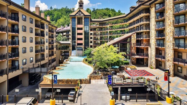 Un hôtel à plusieurs étages doté de balcons, d’une fontaine centrale et d’une façade en pierre.