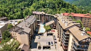 A hotel with multiple floors, a central courtyard, and a mountain backdrop.