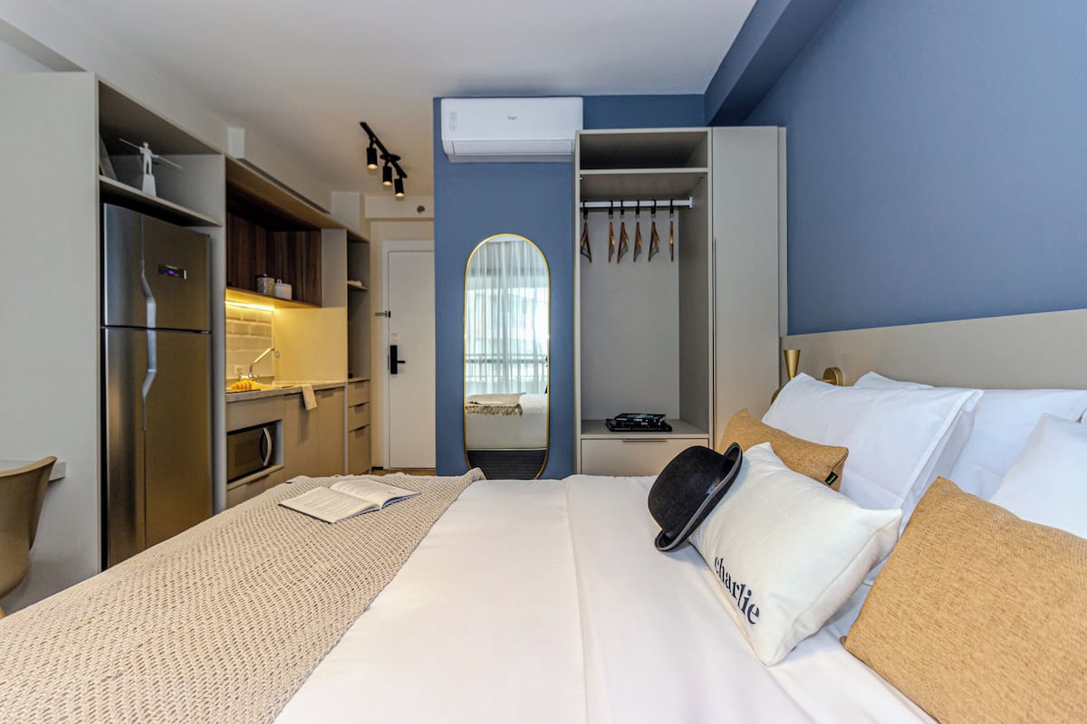 Una habitación de hotel con cama, armario, kitchenette y baño.