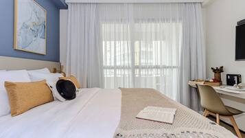 A hotel room with a bed, a desk, and a chair.