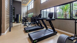 Ein Fitnessstudio mit Laufbändern, Gewichten und Trainingsgeräten.