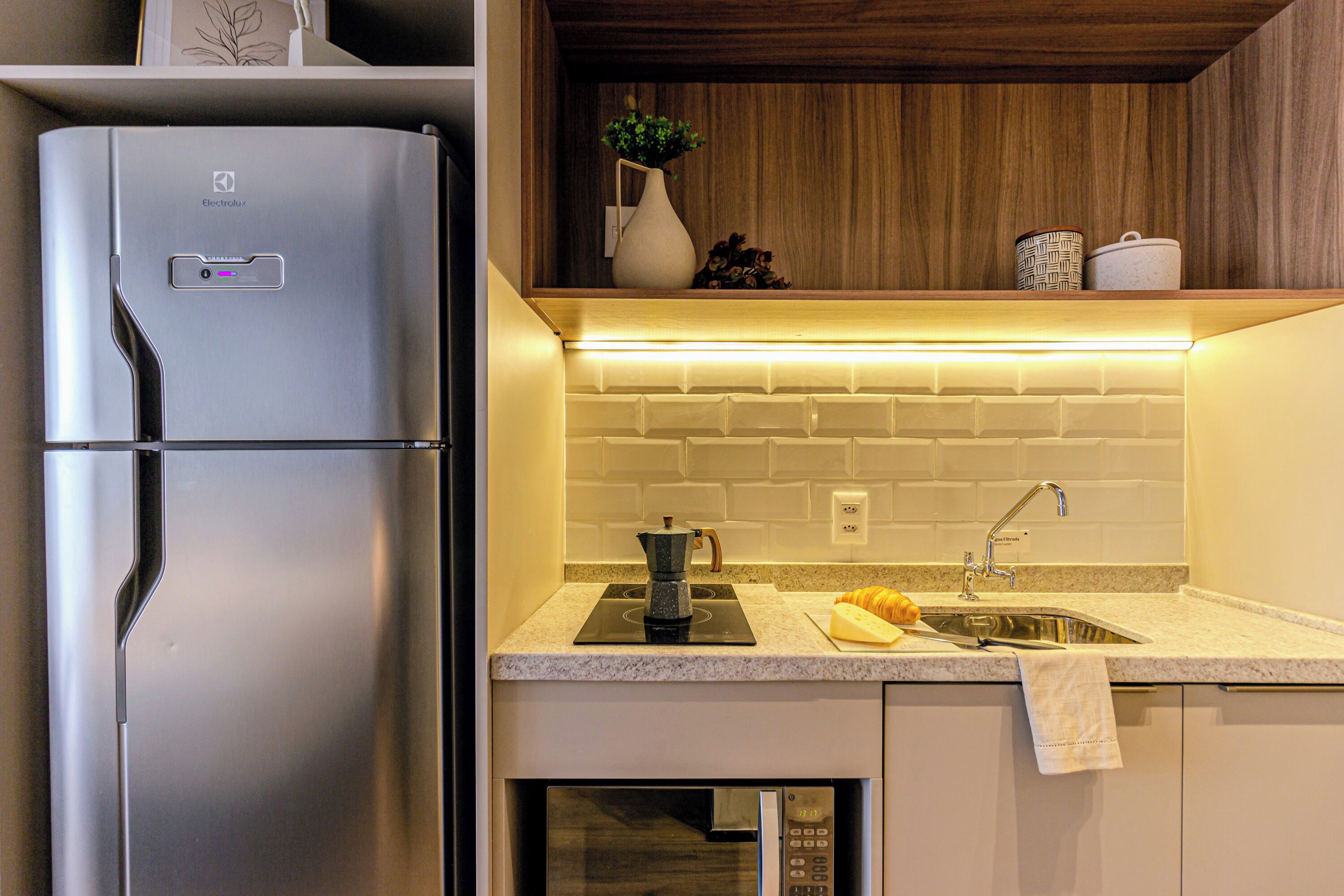 A modern kitchen with a stainless steel refrigerator, a built-in stove, and a sink.