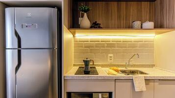 A modern kitchen with a stainless steel refrigerator, a built-in stove, and a sink.