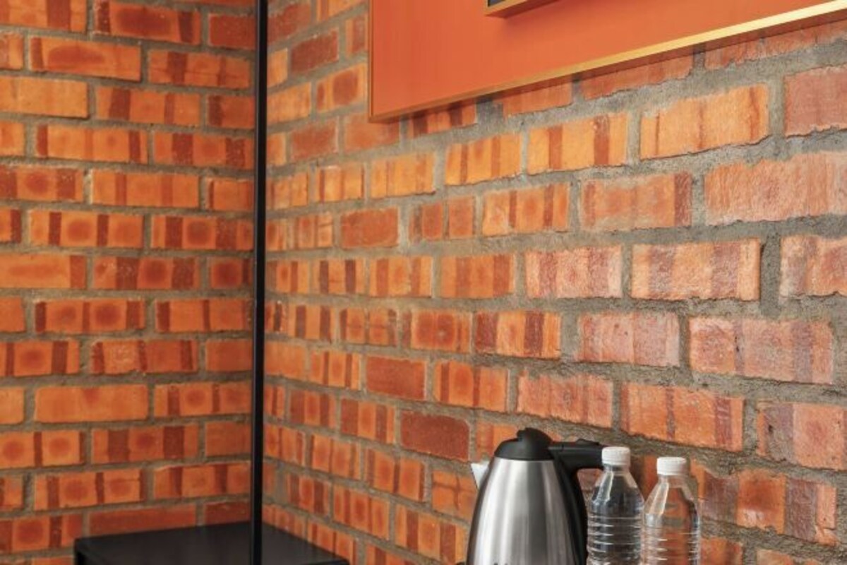 A brick wall with a black table and two bottles.