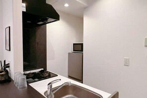 A modern kitchen with a stainless steel sink, a stove, and a microwave. - AKATSUKI Nipponbashi(formeril Hotel Arashi Nipponbashi East No.8111) (Osaka)