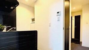 A modern bathroom with a black countertop and a white wall. - Hotel Arashi Nipponbashi East No.8111 (Osaka)