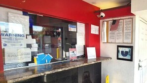 A reception desk with various notices and a security camera. - Saratoga Motel By Capital O Near Midway Airport Chicago IL (Chicago)