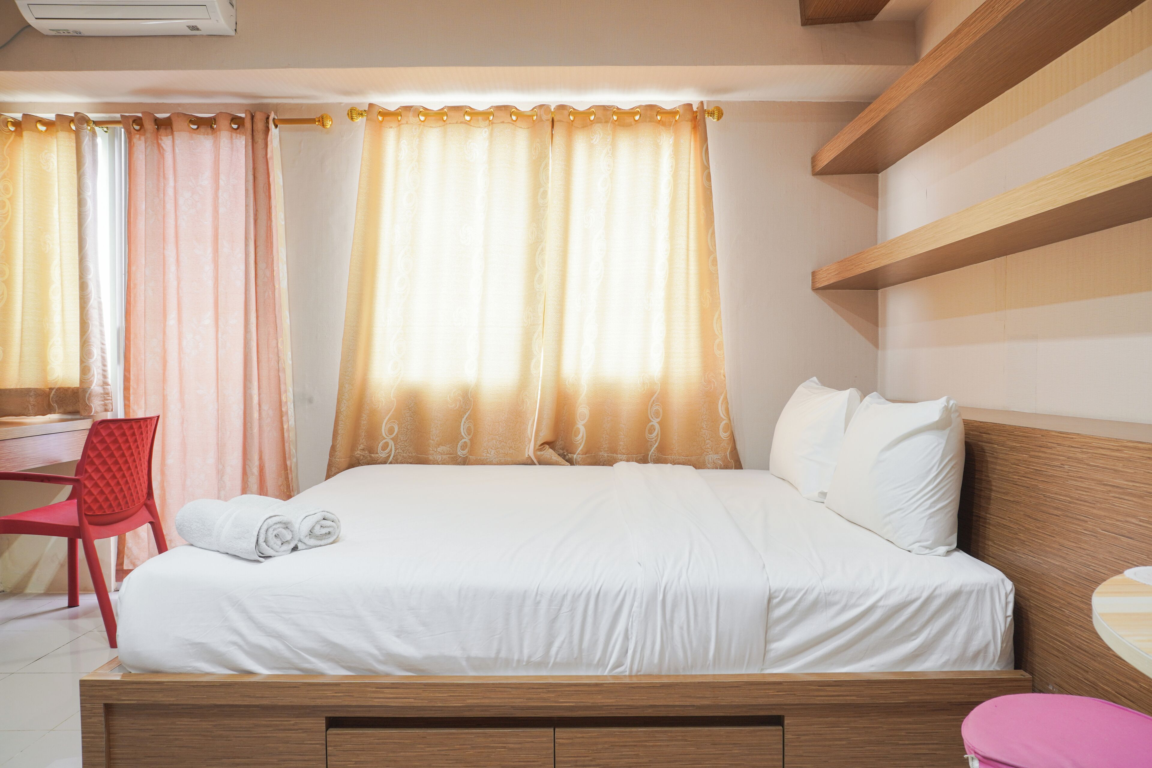 A bedroom with a bed, a desk, and a chair.