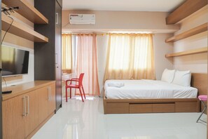 Une chambre d’hôtel moderne équipée d’un lit, d’une télévision, d’un bureau et d’une chaise.