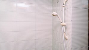A shower with a handheld showerhead and a wall-mounted faucet. - Minimalist Studio At Margonda Residence 3 Apartment (Depok)