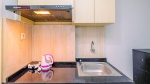 Een compacte keuken met een inbouwoven, een spoelbak en een klein aanrecht.