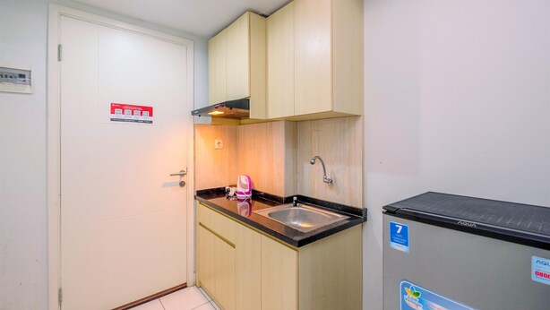 Een kleine keuken met een spoelbak, kastjes en een waterdispenser.