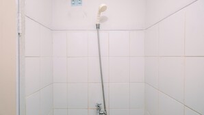 Een douche met een handdouche en een kraan op de muur.