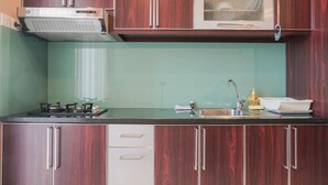 Una cocina con armarios de madera, un microondas, una estufa a gas y un lavamanos.