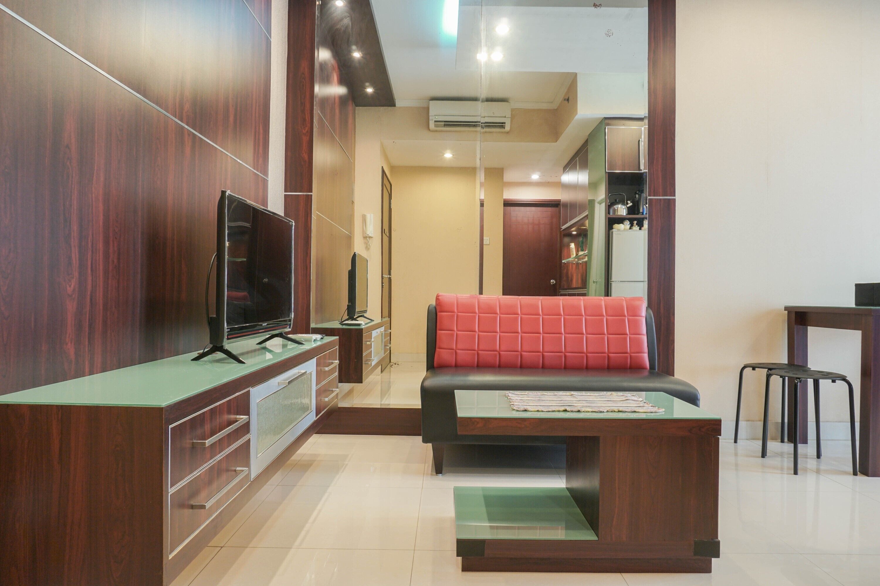 A modern living room with a sofa, TV, and a small dining area.