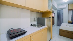 Een kleine keuken met een ingebouwde kookplaat, een spoelbak en een klein aanrecht.