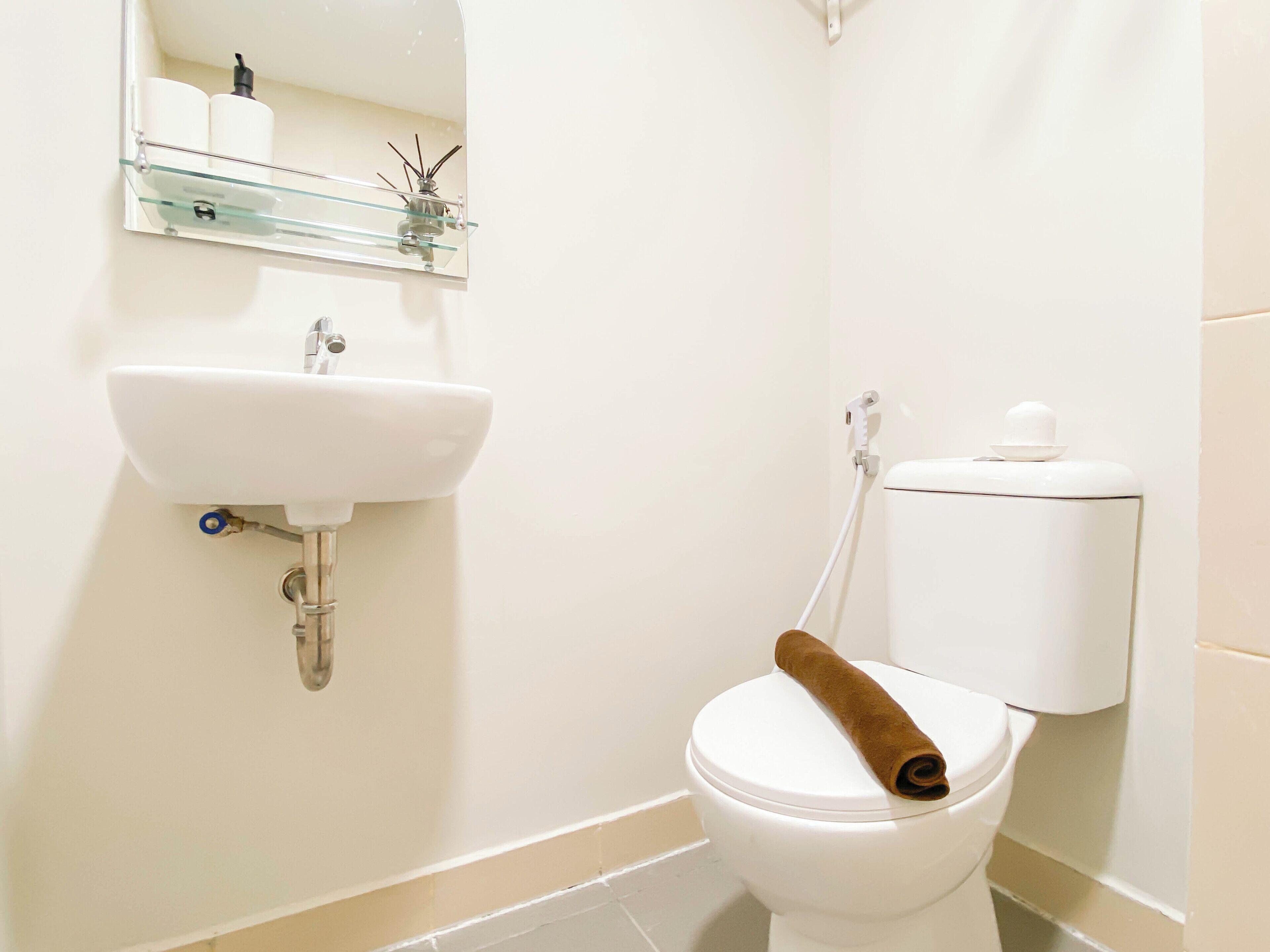 A bathroom with a white sink, toilet, and mirror.