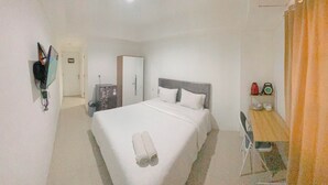 Een hotelkamer met een groot bed, een bureau en een stoel.