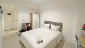 Een hotelkamer met een bed, een bureau en een stoel.