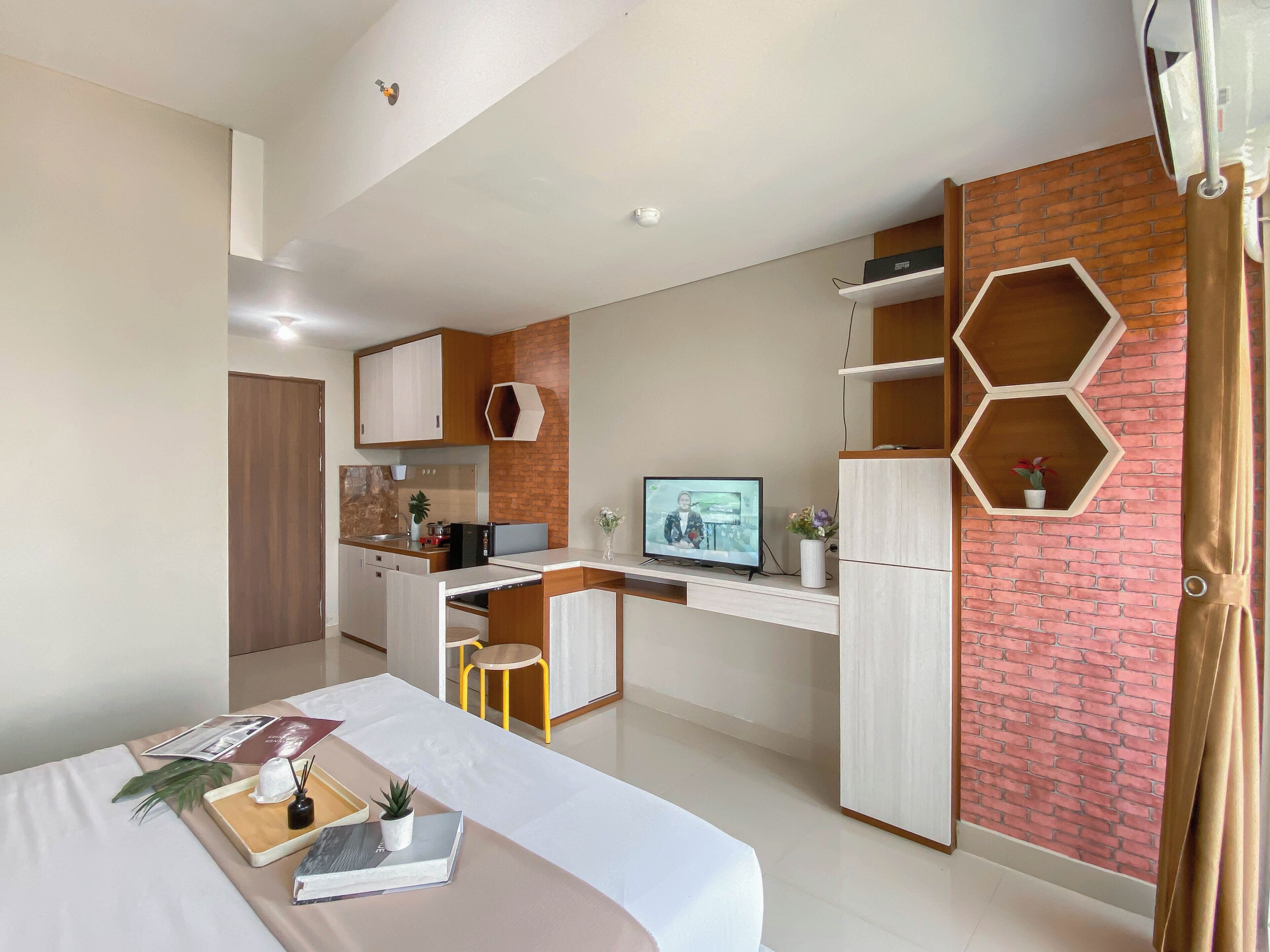 Una habitación de hotel moderna con cama, escritorio y kitchenette.