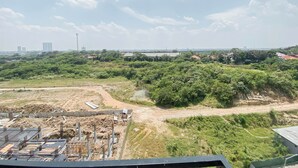 A construction site with a dirt road and green vegetation. - White Accent Studio At Apartment Meikarta Near Paramadina University (Cikarang)