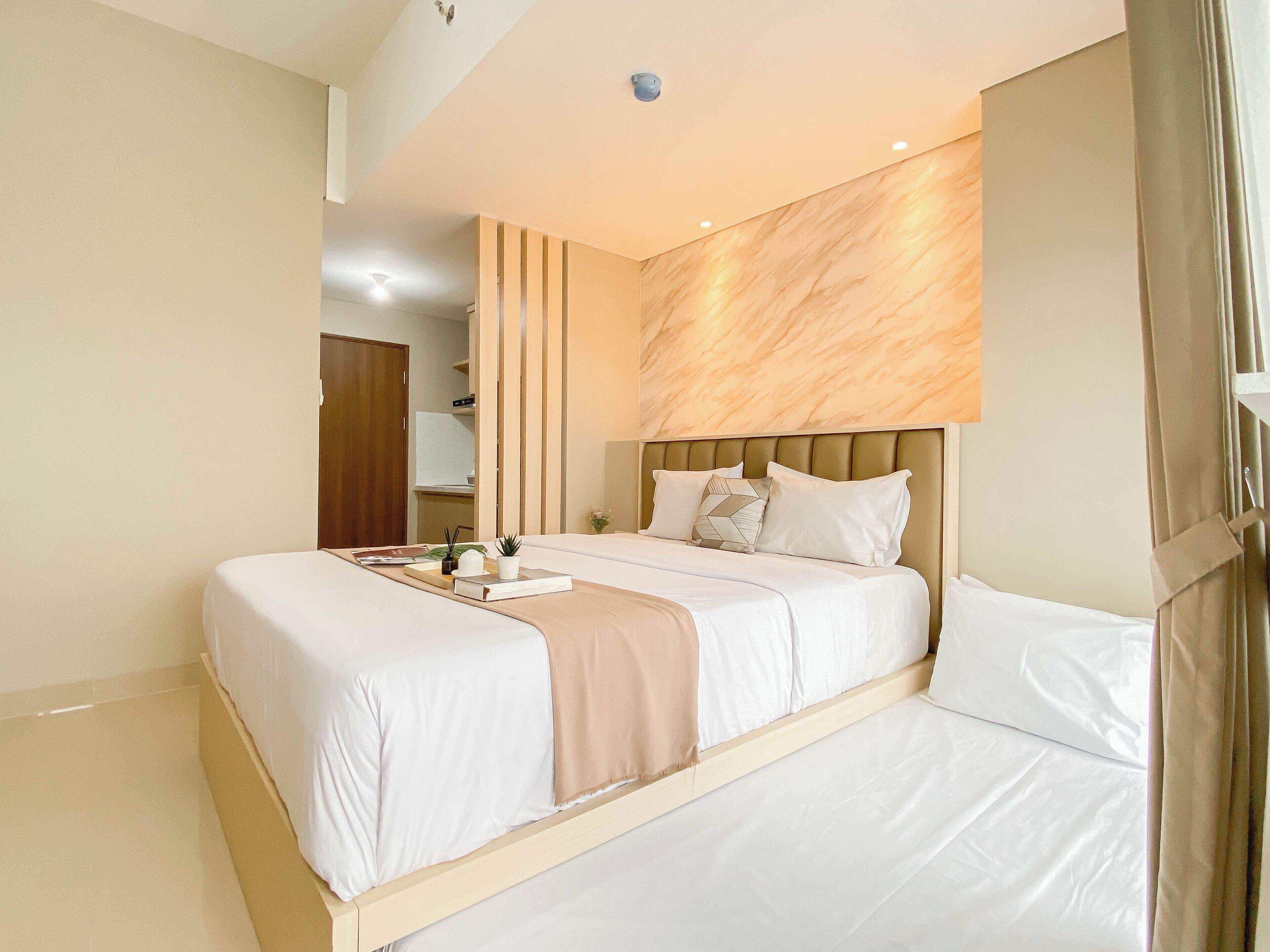 A modern hotel room with a large bed, a bedside table, and a nightstand.