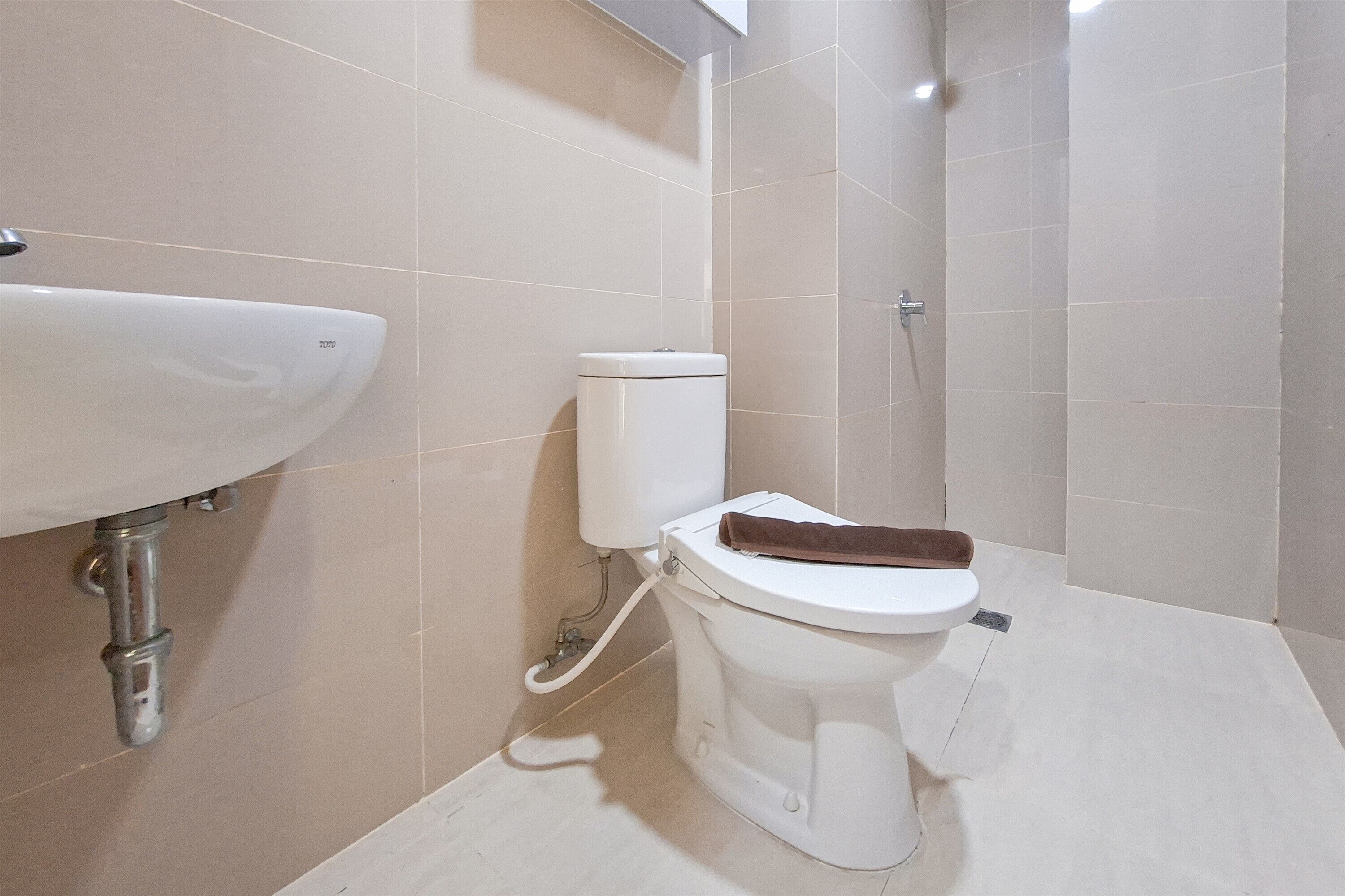 A bathroom with a white toilet, a sink, and a shower.