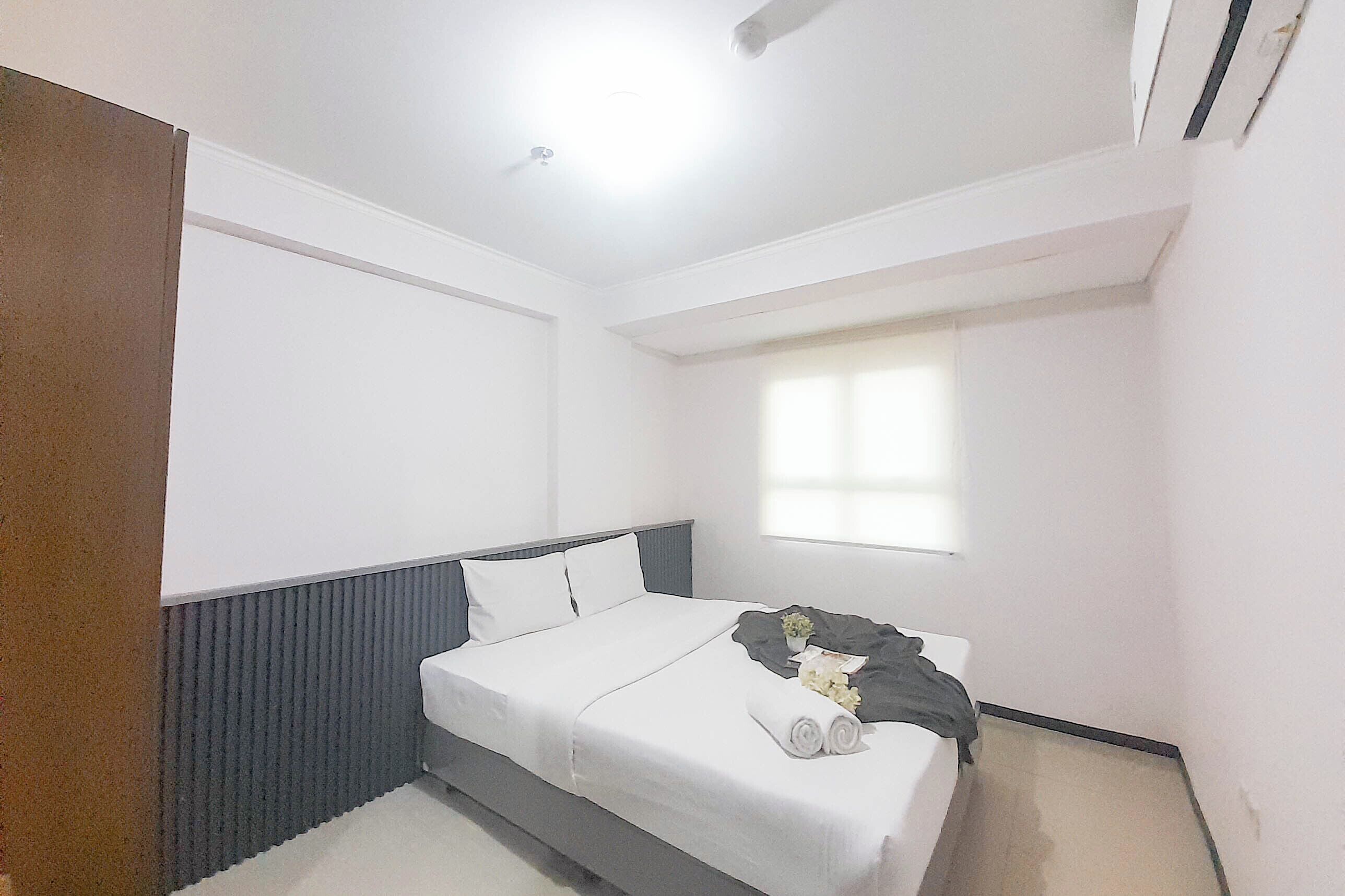 Una camera da letto con un letto, una finestra e una ventola a soffitto.