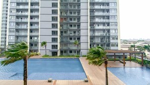 A modern apartment building with a rooftop pool area. - Serene Stay 2Br At Daan Mogot City Apartment (Jakarta)