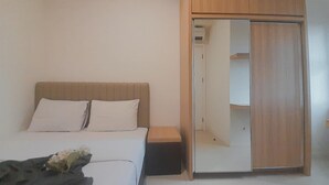 Une chambre à coucher avec un lit, une table de chevet et une armoire.