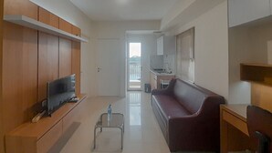 Un salon moderne avec un téléviseur, un canapé et une table basse.