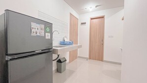 A modern kitchen with a refrigerator, sink, and wooden cabinets.