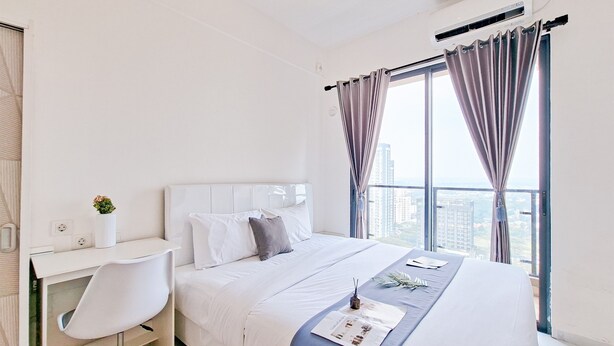 Una habitación de hotel moderna con una cama grande, un escritorio y vistas a la ciudad.