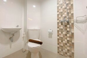 A bathroom with a toilet, sink, and shower. - Wooden Nest Studio At The Alton Apartment (Semarang)