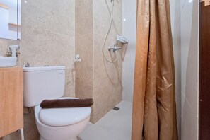 A bathroom with a toilet, shower, and a towel rack. - Studio Near Transpark Mall Bintaro At Transpark Bintaro Apartment (South Tangerang)