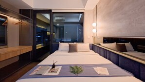 A modern hotel room with a large bed, a bedside table, a mirror, and a view of the cityscape through the window. - 1Br Near Binus Alam Sutera At Collins Boulevard Apartement (Tangerang)