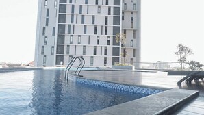 A modern building with a pool area. - 2Br Near Marvell City Mall At Linden Apartment (Surabaya)