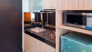 A modern kitchen with a black countertop, stainless steel sink, and a microwave.