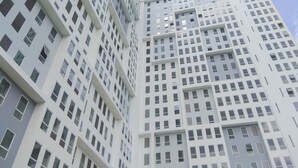 A high-rise building with a grid of windows and balconies. - Standard Look Studio At Patraland Urbano Apartment (Bekasi)