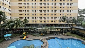 Un hôtel doté de nombreux balcons, d’un espace de jeux pour enfants et de deux piscines.