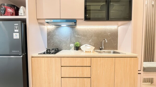 Une cuisine compacte équipée d’une cuisinière intégrée, d’un évier et d’un four à micro-ondes.