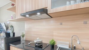 Uma cozinha moderna com bancada preta, pia de aço inoxidável e armários de madeira.