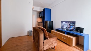Ein modernes Wohnzimmer mit einem braunen Sofa, einem Holzschrank und einem Fernseher, der einen Streaming-Dienst anzeigt.
