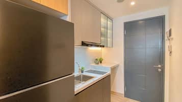 A modern kitchen with a built-in refrigerator, stainless steel sink, and a dark wooden cabinet.